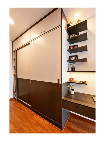 Organized elegance meets functional style in this sleek storage solution, which combines a sliding door wardrobe with an integrated study desk and open shelving.