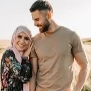 A smiling, modern Muslim couple enjoying a moment in a sunlit field. This shows that piety and modern life can go hand in hand, and we cater to profiles of all backgrounds.