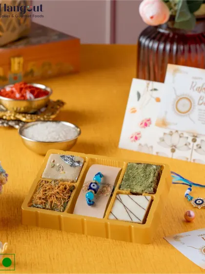 This limited-edition brownie box is perfect for Rakshabandhan. It features unique fusion flavors like Matcha, Kaju Katli, and Kunafa brownies, and comes paired with an Evil Eye Rakhi.