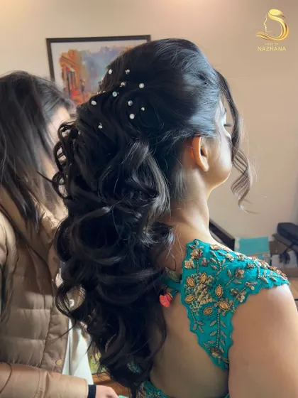 A behind-the-scenes shot of the pearl-studded textured ponytail, showing the volume and movement in the curls.
