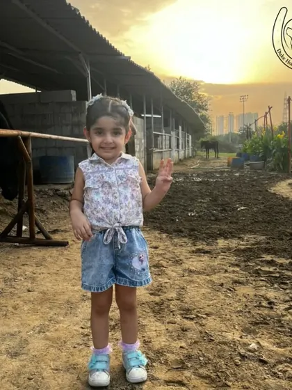 A happy child poses near the stables at sunset, capturing the calm and beautiful atmosphere of the club.