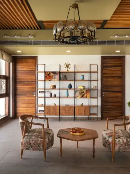 The second-floor lobby of Ashraya Residence unfolds as a spacious, well-lit sanctuary. Bathed in natural light, the area exudes warmth through its earthy palette of rich browns and soft whites.