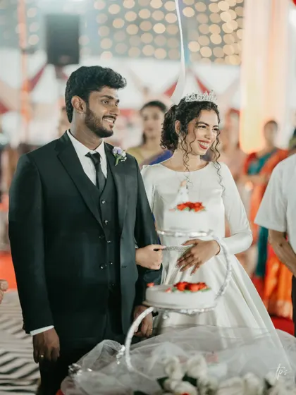 The cake ceremony. A happy, candid moment from the reception, with the bride looking radiant and joyful.