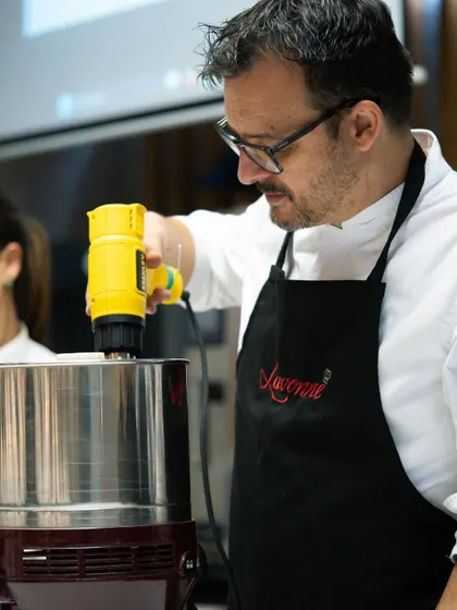 Chef Olivier Fernandez from EPGB Barcelona leads a bean-to-bar chocolate masterclass. Here he is using a melanger to grind cacao nibs, a key step in the chocolate-making process.