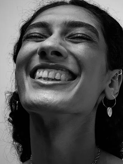 Another moment of pure happiness from the same series. The high-contrast lighting emphasizes the texture of her smile and the light in her eyes.