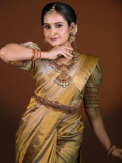 A portrait of grace. This photo captures the full effect of the bridal makeup, hair, and styling, showing how every element from the bindi to the saree drape comes together.