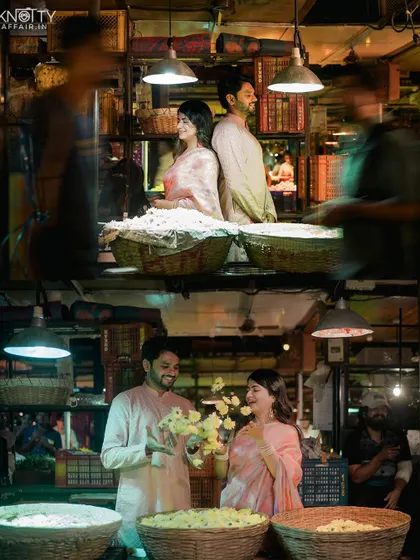 A behind-the-scenes feel at the flower market. The motion blur of people passing by emphasizes the couple as a calm center in the midst of the city's energy.