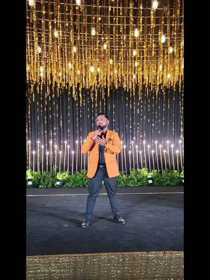 Another angle of me on the Sangeet stage, holding the mic, ready to bring the sparkle.