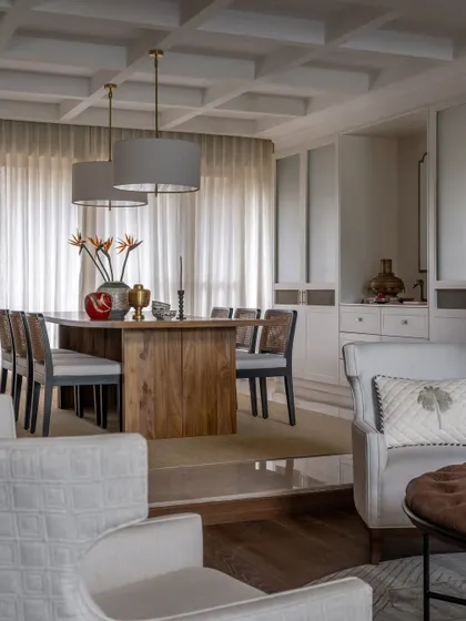 Details from the dining space, where classic forms meet modern sensibilities. The large drum pendants anchor the long table, while the sheer curtains diffuse light beautifully, creating a soft and inviting ambiance for meals.