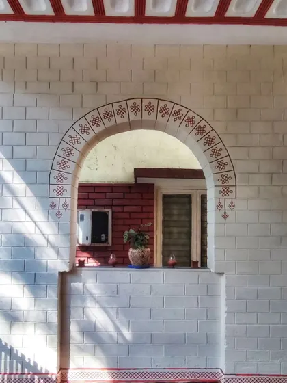 We painted a minimal Kolam border around this archway to add a subtle traditional touch to the home's entrance. It shows how we can work with existing architectural features like brick walls.