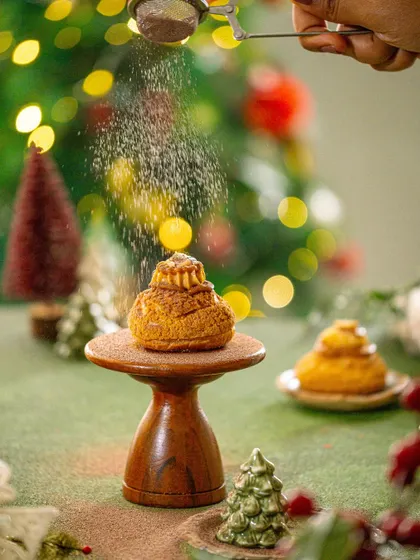 A duplicate of image 113, capturing the action of dusting the pastry.