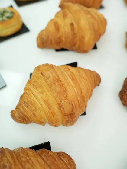 A close-up of a classic croissant, highlighting its many flaky layers. This is the kind of professional-quality pastry you will learn to create from scratch.