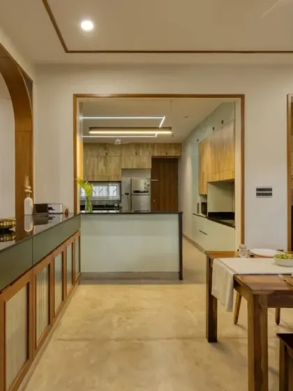 A soft archway provides a beautiful view from the dining room into the mint-green kitchen, connecting the two spaces visually.