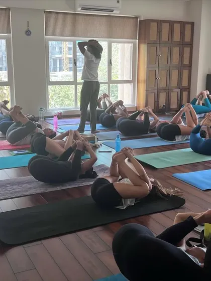 Students practicing Ananda Balasana (Happy Baby Pose) during a hip opening session. Even simple poses can be profoundly deep when approached with mindfulness and proper guidance.