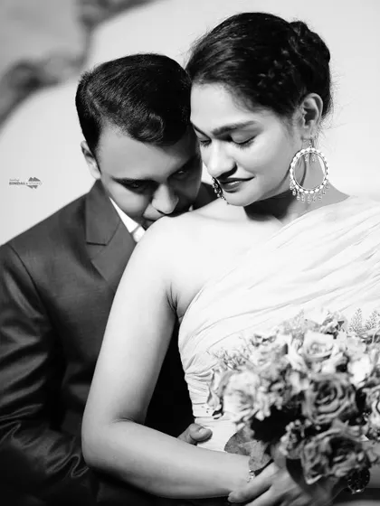 An intimate black and white close-up that focuses on the emotion between the couple, while still hinting at the elegance of her gown and bouquet.