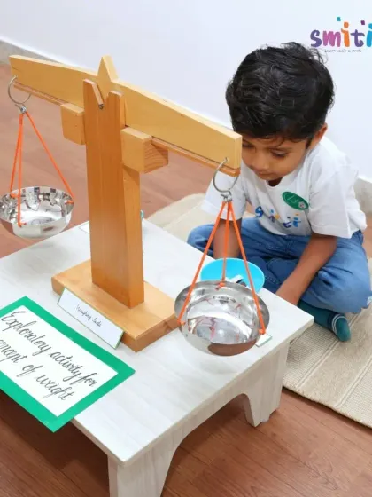 A child demonstrates the concept of weight using a balancing scale, an activity from our "Coconut Chronicles" project. This shows parents how we make scientific concepts tangible.