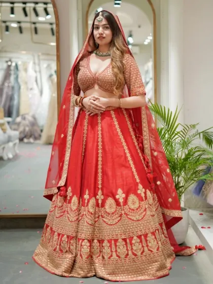 This classic red bridal lehenga features a beautiful A-line silhouette with traditional gold motifs along the border and a sequined blouse. It’s a timeless choice for your pheras.