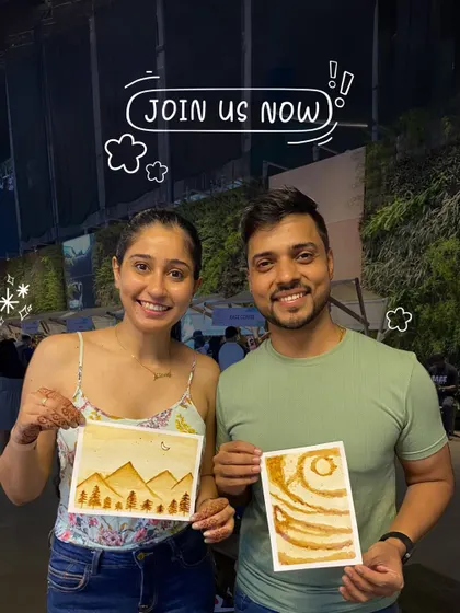 A happy couple shows off the coffee paintings they made together. These unique workshops use coffee to create beautiful monochrome landscapes.