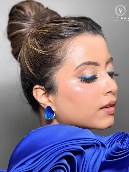 A pop of color can transform a whole look. For this modern party style, I used a sharp, electric blue winged liner to create a statement eye, balanced with glowing skin and a neat top knot for a chic and unforgettable finish.