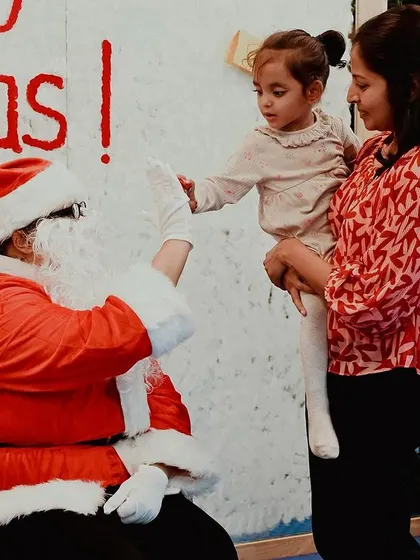 A child gives Santa a high-five, a magical moment from our Christmas party.