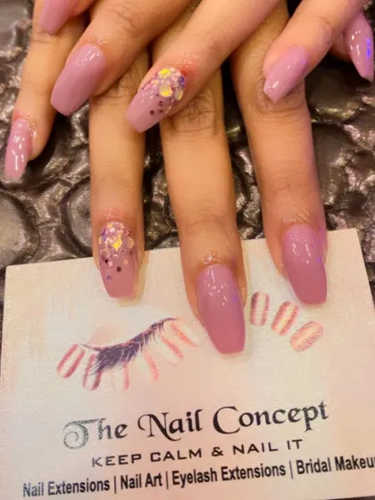 A soft mauve color on coffin-shaped nails. The accent nails feature a fun, chunky multi-colored glitter for a playful pop of sparkle.