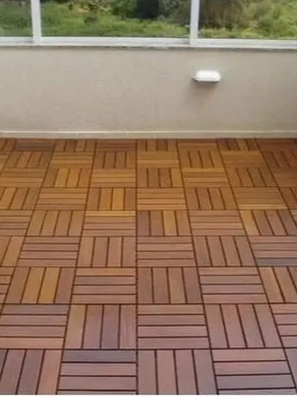 A clean installation of interlocking WPC deck tiles on a balcony, providing a sophisticated and comfortable surface.