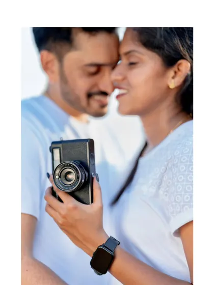 An intimate close-up of the couple, with the vintage camera creating a unique foreground element for their pre-wedding photo.