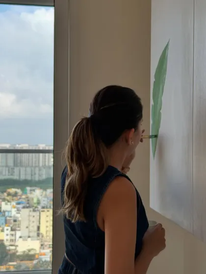 A behind-the-scenes shot of me painting the tropical crockery unit, with a beautiful city view in the background. A great workspace always inspires great work.
