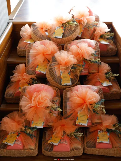 A collection of beautifully wrapped favors stacked on a wooden staircase, creating an artful display that is both practical and aesthetically pleasing.