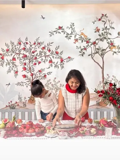 A beautiful Chinoiserie-style wallpaper featuring pomegranate trees and birds, creating an elegant and festive atmosphere in this dining space.