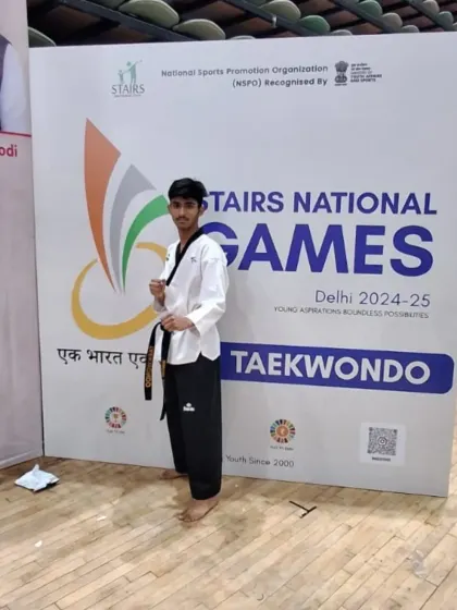 A black belt student posing confidently at the Stairs National Games. Competing at this level builds immense confidence and experience.