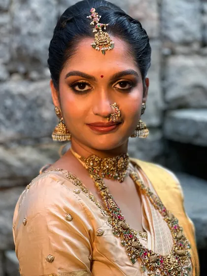 A close-up portrait that captures the essence of a traditional bride. The focus is on the kohl-rimmed eyes and flawless skin, a signature style for a timeless South Indian wedding look.