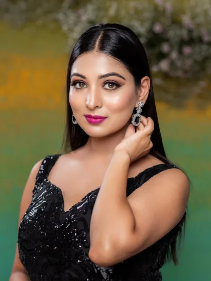 A close-up portrait showcasing a bold and beautiful party look. The sharp winged liner and bright pink lip create a stunning contrast against the black dress.