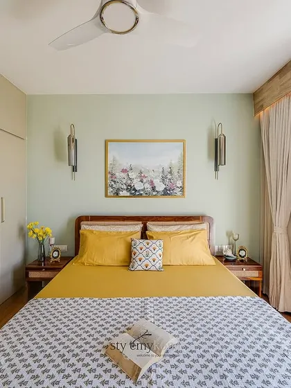 In this guest bedroom, we created a welcoming sanctuary by using a neutral palette for the walls and wardrobes. We then added a pop of brightness with yellow bedding to make the space feel fresh, cozy, and inviting.