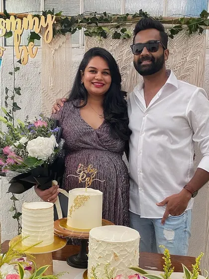 The happy couple at their baby shower. This setup shows how we can blend modern elements like macrame art with lush floral arrangements for a celebration that feels both trendy and personal.