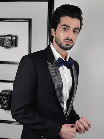 The sequined lapel tuxedo, viewed from another angle, shows its sharp tailoring. It's a modern classic, designed for the man who wants his formal wear to have a touch of personality and flair.