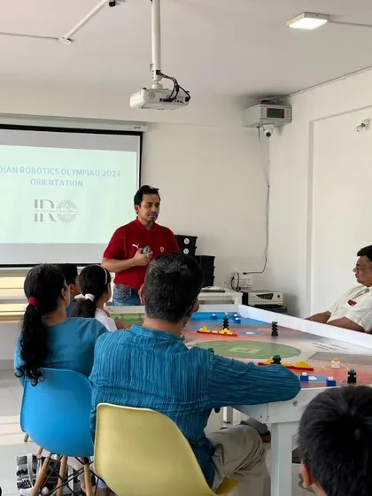 Our instructor presenting during an IRO orientation, explaining the competition rules and training process to an attentive audience of parents and future roboticists.