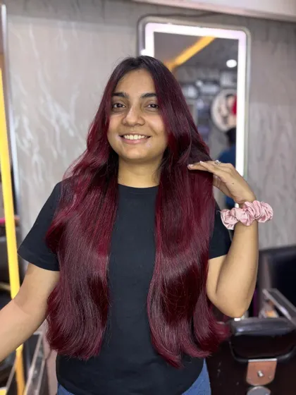 The happy client showing off her new cherry red hair. Her smile is as bright as her new color.