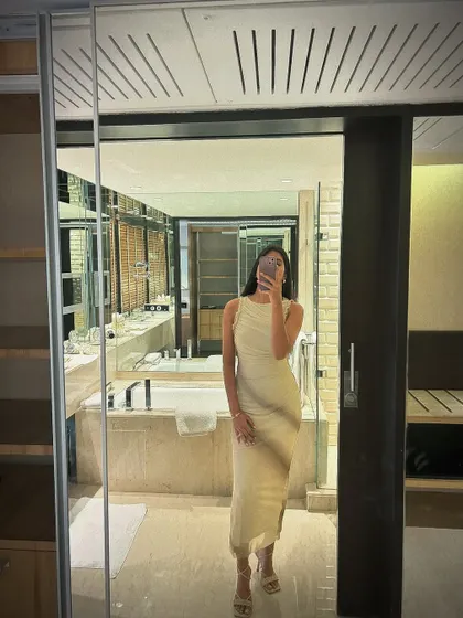 A full-length mirror selfie showing the complete look. The simple silhouette paired with strappy heels created a chic and modern red carpet style.