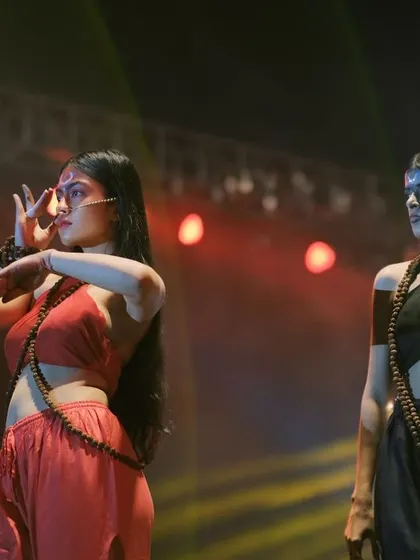 A creative dance performance during a college fashion show. This shot captures the fusion of traditional dance mudras with modern theatrical presentation.