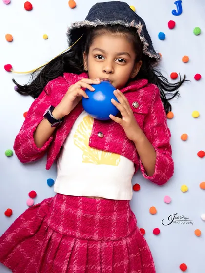 A creative overhead shot with colorful pom-poms adds texture and fun. I love experimenting with different angles and compositions to create unique portraits.