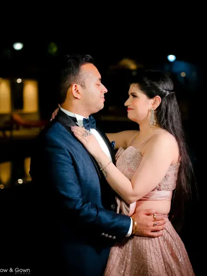 A romantic nighttime portrait from an engagement shoot. The couple shares an intimate look, with the dark background making them the sole focus.