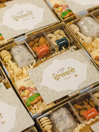 Custom "Shubh Deepavali" boxes filled with assorted dry fruits and honey dippers. This is a great example of a traditional yet elegant gifting option for corporate clients.