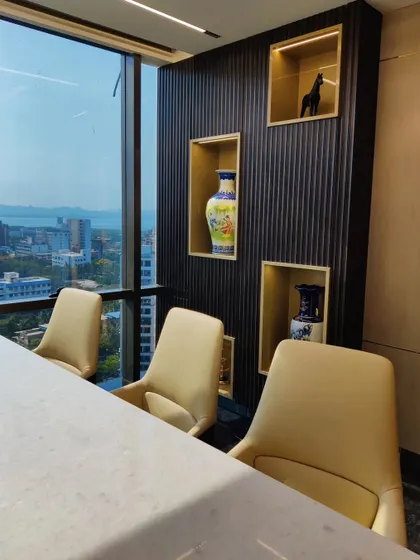 A view of the meeting area within an executive cabin, featuring display niches with gold-leaf interiors. These niches provide a curated space for art and decor, adding a personal touch to the professional environment.