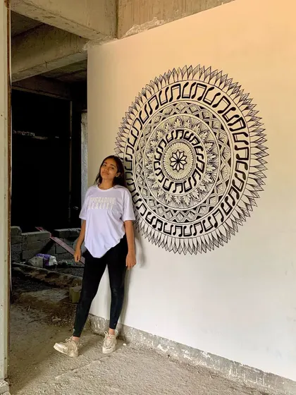 Let's skip to the good part. A photo of me with a finished music themed mandala, painted on site in a building under construction.