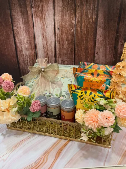 Another one of our beautiful Rakhi snack hampers. The pastel floral arrangement complements the colorful packaging of the Indian snacks, creating a delightful gift.