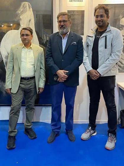 Posing with esteemed guests at my exhibition booth, surrounded by my charcoal artworks.