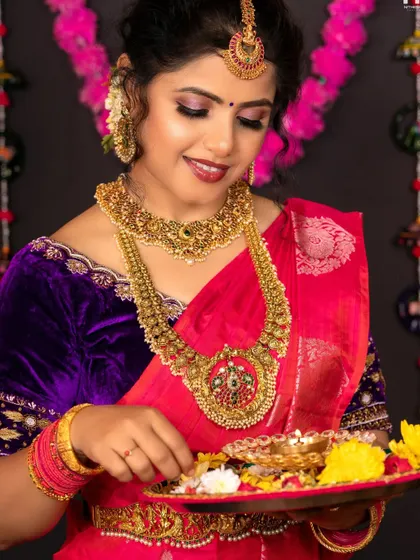 A beautiful shot of the model with a plate of flowers, her traditional jewellery completing the festive look.