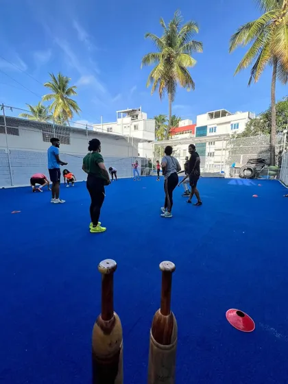 A group trains on our bright blue turf under a clear sky. This image showcases our vibrant, open-air training environment, a refreshing alternative to a typical gym.