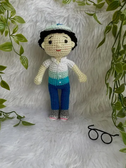 This handsome little boy replica doll features curly hair, a cap, and removable glasses. It’s so fun to create these little details that make each doll a true mini-me.
